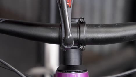 Meticulous-handlebar-installation-on-mountain-bike-by-bicycle-mechanic---closeup-of-torque-wrench-tightening-bolts-with-even-pressure