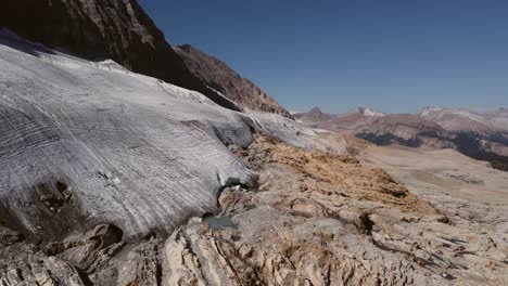 Glacier-in-mountains-puddles-descending-aerial