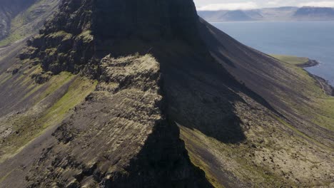 Drone-orbiting-around-a-knife-edge-peak-in-Iceland-in-the-Western-Fjords-of-Svalvogar-mountain