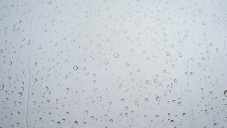 Eine-Zeitlupenaufnahme-Von-Schweren-Regentropfen,-Die-Auf-Einer-Fensterscheibe-Landen