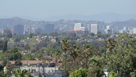 Wide-view-of-Los-Angeles-skyline-with-Century-City,-palm-trees,-and-mountains-in-the-background