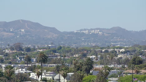 Wide-view-of-Los-Angeles-skyline-with-palm-trees-and-Santa-Monica-Mountains-in-the-background