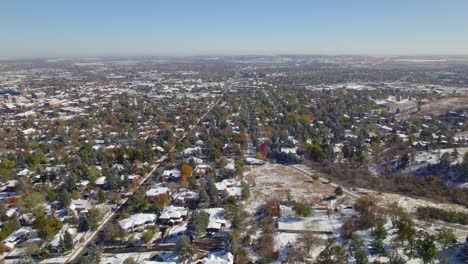 Drone-flight-on-a-calm-fall-day-with-light-snow-on-the-ground-above-neighborhoods-in-Boulder-Colorado-USA