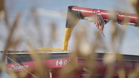 Combine-Harvester-Chute-Pouring-Freshly-Harvested-Grain-Crop-into-Grain-Bin,-Slow-Motion