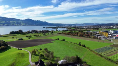 Aerial-Flying-Over-Serene-Farmland-Beside-Lake-Constance-Near-Bollingen,-Switzerland