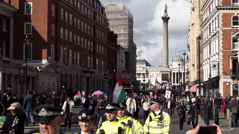 Nelson’s-Column-can-be-seen-as-a-unit-of-Metropolitan-police-officers-march-alongside-pro-Palestinian-protestors-making-their-way-down-Whitehall-on-a-sunny-day