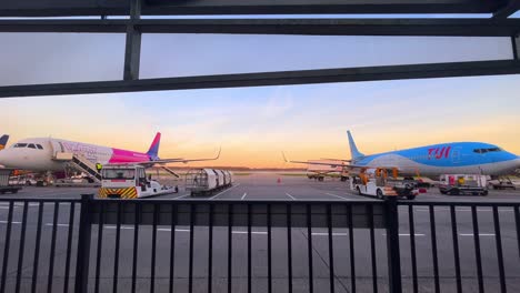 Airplanes-of-Wizzair-and-TUI-waiting-for-passenger-in-front-of-terminal-on-the-ground