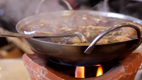 Cocinar-Y-Mezclar-Una-Mezcla-De-Diferentes-Carnes-En-Una-Sopa-De-Fideos-Tailandesa-Muy-Caliente,-Una-Comida-Tradicional-En-Tailandia