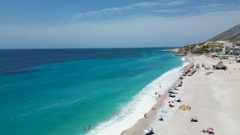 Luftaufnahme-Eines-Wunderschönen-Sandstrandes-Am-Mittelmeer-Mit-Touristen,-Die-An-Einem-Sommertag-Am-Ufer-Schwimmen