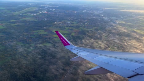 Blick-Auf-Eindhoven-Aus-Dem-Flugzeugfenster-Mit-Sichtbarem-Flugzeugflügel