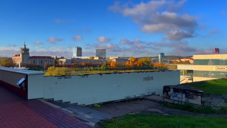 Handheld-view-on-Vilnius-from-old-worn-Soviet-balcony-pov-while-lady-passes-by