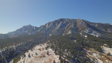 Snow-covering-the-flatirons-nature-landscape-on-a-clear-fall-day-in-Boulder,-Colorado,-USA-Drone-Aerial-Video