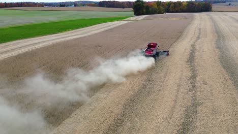 farm-combine-harvesting-soybeans-on-a-midwestern-farm-field,-aerial-drone