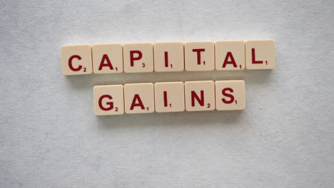 Human-hands-creating-the-phrase-"Capital-Gains-Taxes