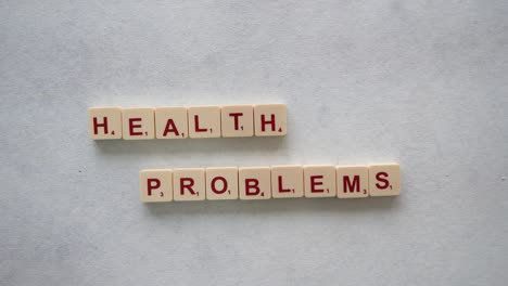 Human-hands-creating-the-phrase-"health-problems"-with-red-letters