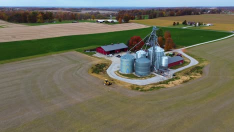 Midwest-farm-with-grain-silos-and-barns,-aerial-drone