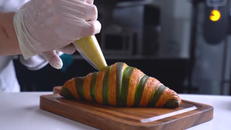 The-French-pastry-chef-adds-filling-to-the-croissant