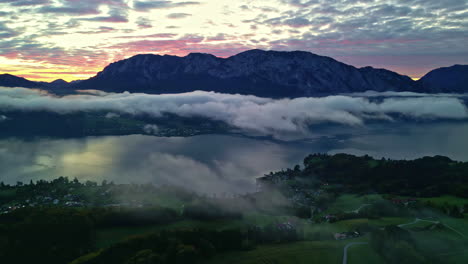 Aerial-view-of-low-hanging-clouds-above-lake-Attersee,-dramatic-dusk-in-Austria
