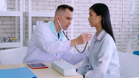 Doctor-in-professional-uniform-examining-patient-at-hospital