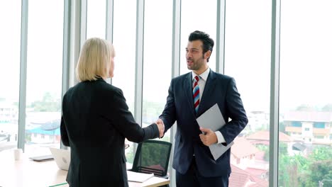 Business-people-handshake-with-friend-at-office