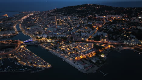 Drone-captures-by-night:-Sète's-seaside-allure,-lively-port,-and-maritime-legacy