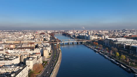 Aerial-charm:-Paris,-Seine,-Île-de-la-Jatte,-La-Défense,-and-a-sunny-barge-cross