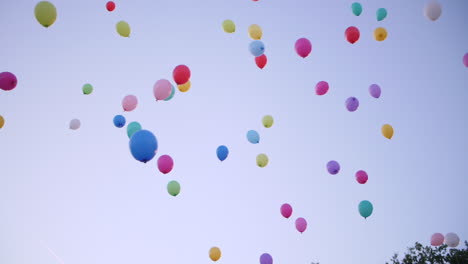 Mehrfarbige-Partyballons-Fliegen-In-Den-Himmel-Bei-Sonnenuntergang.