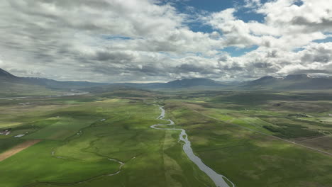 Toma-Aérea-Del-Paisaje-Rural-Islandés-Con-Río-Y-Campos.