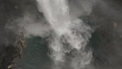 Poderosa-Cascada-En-El-Agua-De-Islandia-Rompiendo-Sobre-Una-Roca-En-Cámara-Lenta-Aérea