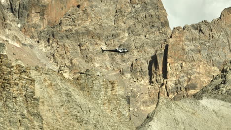 Stationary-helicopter-in-flight-doing-maintenance-job-in-the-french-alps