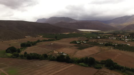 Landschaft-Mit-Bergen-Und-Wolkenfeldern,-Weinbergen-In-Südafrika,-Luftaufnahme