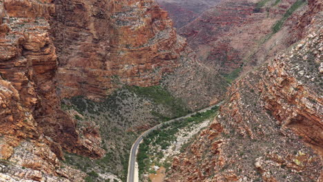 Beautiful-winding-road-crossing-a-rocky-canyon-in-South-Africa-aerial-view