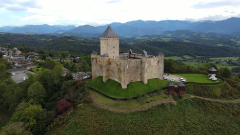 Aerial-shot-of-Castle-of-Mauvezin-atop-a-green-hill.