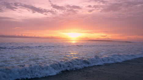 Die-Lebendigen-Farben-Des-Sonnenaufgangs-Spiegeln-Sich-Im-Meerwasser-Und-Zeichnen-Die-Silhouette-Der-Fernen-Küste-Nach