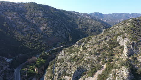 Aerial-steep-sided-gorge-de-l'herault-with-aqueduct-along-the-hills-France-sunny