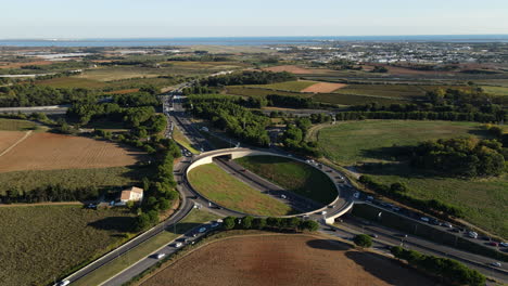 Aerial-view-of-a-prominent-roundabout-in-Montpellier,-framed-by-lush-green-field