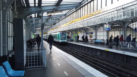 U-Bahn-U-Bahn-Fährt-Im-Freien-Vom-Bahnhof-Stalinard-In-Paris-Ab,-Menschen-Gehen-Zu-Fuß