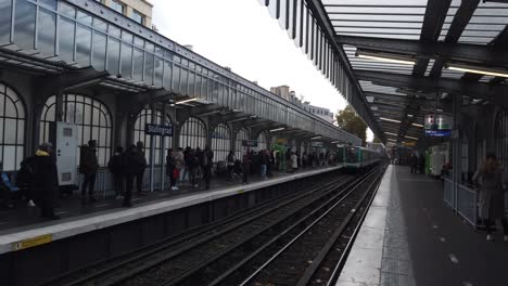 Die-Menschen-Warten-Auf-Den-Zug,-Der-Im-Freien-Am-Bahnhof-Stalingard-In-Der-Pariser-U-Bahn-Ankommt