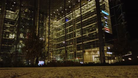 Ground-level-tilt-up-steel-and-glass-urban-city-building-on-dark-night