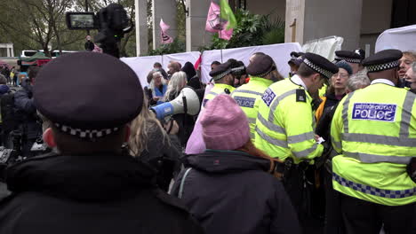 A-Metropolitan-police-evidence-gatherer-films-using-a-video-camera-on-a-monopod-as-other-officers-talk-with-Extinction-Rebellion-climate-change-activists-during-a-protest