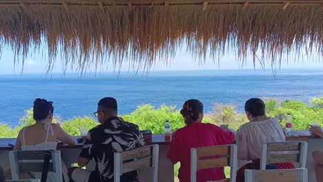 A-number-of-Visitors-are-eating-at-restaurant-on-the-edge-of-Crystal-Bay-beach,-Nusa-Penida-Island,-Bali