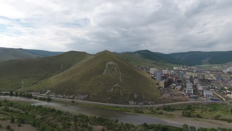 Genghis-Khan-Se-Enfrenta-A-Una-Colina-En-Ulan-Bator,-Mongolia.-Tiro-Aéreo-Con-Drones-Día-Nublado