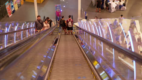 Shoppers-and-tourists-are-going-up-and-down-the-escalators-inside-a-shopping-center-in-Pattaya,-Chonburi