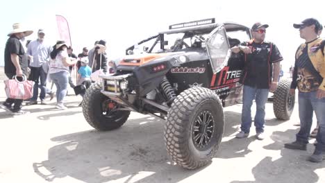 People-showing-a-raid-rally-buggy-in-Baja-500-race-in-Mexico-at-day-time