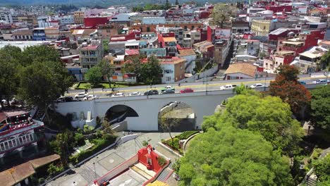 Aerial-drone-tilt-up-shot-over-a-historical-bridge-of-Xalapa,-Xalapa-city,-Veracruz,-Mexico-at-daytime,-colorful-city-in-summer-travel-over-america-historic-place-touristic-point