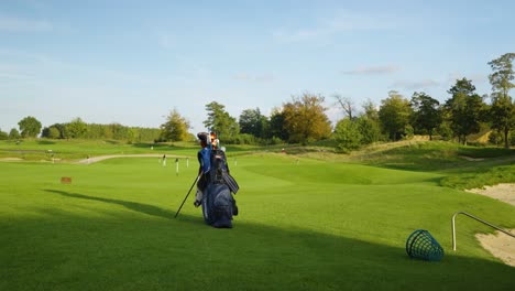 Lone-golf-bag-filled-with-golf-clubs-stand-on-the-green-golf-course-with-flags