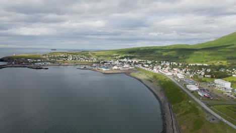 Embrace-Húsavík-from-above-in-this-4K-drone-sweep,-capturing-the-town's-full-charm,-framed-by-the-serene-waters-that-cradle-its-shores