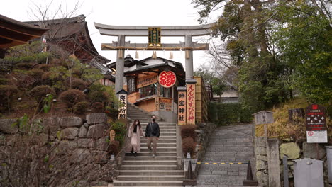 Joven-Pareja-Asiática-Con-Máscaras-Caminando-Por-La-Escalera-Del-Santuario-Jishu-jinja-Tomados-De-La-Mano-Dentro-Del-Templo-Kiyomizudera-En-Kyoto