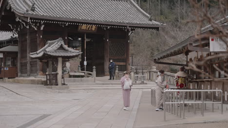 Junge-Asiatische-Frauen-In-Bunten-Kimonos-Vor-Dem-Eingang-Des-Kiyomizudera-Tempels-Kaufen-Eintrittskarten,-Während-Der-Covid-19-Pandemie-Gab-Es-Nur-Sehr-Wenige-Besucher