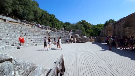 Journey-Through-History:-Tourists-Explore-the-Ancient-Amphitheater-and-Stone-Walls-of-Butrint,-an-Enchanting-Archaeological-Site
